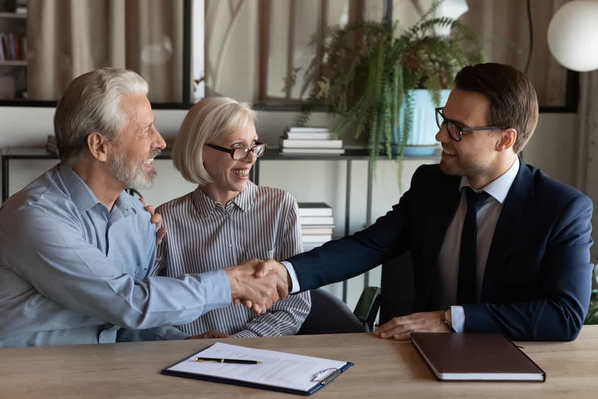 Insurance agent shaking hands with senior couple