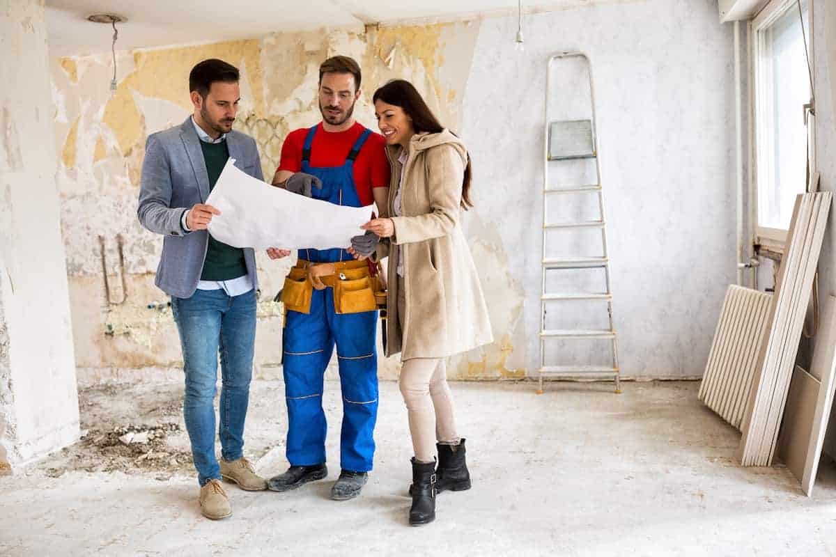 Contractor going over blueprints with a couple