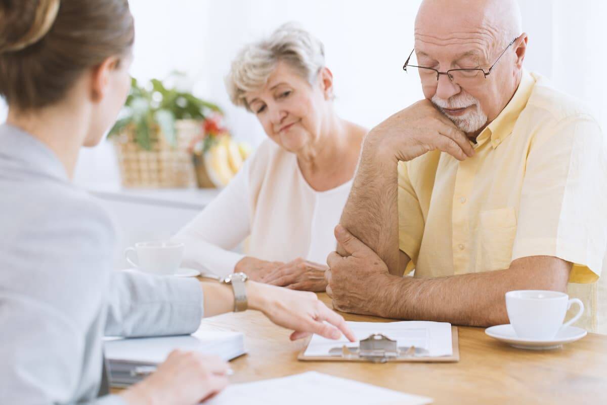 Elderly couple looking over paperwork with an insurance agent