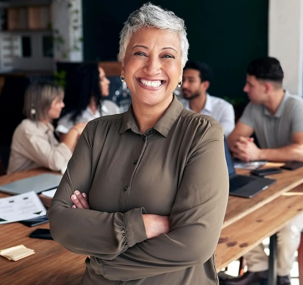a woman smiling at a table with her team