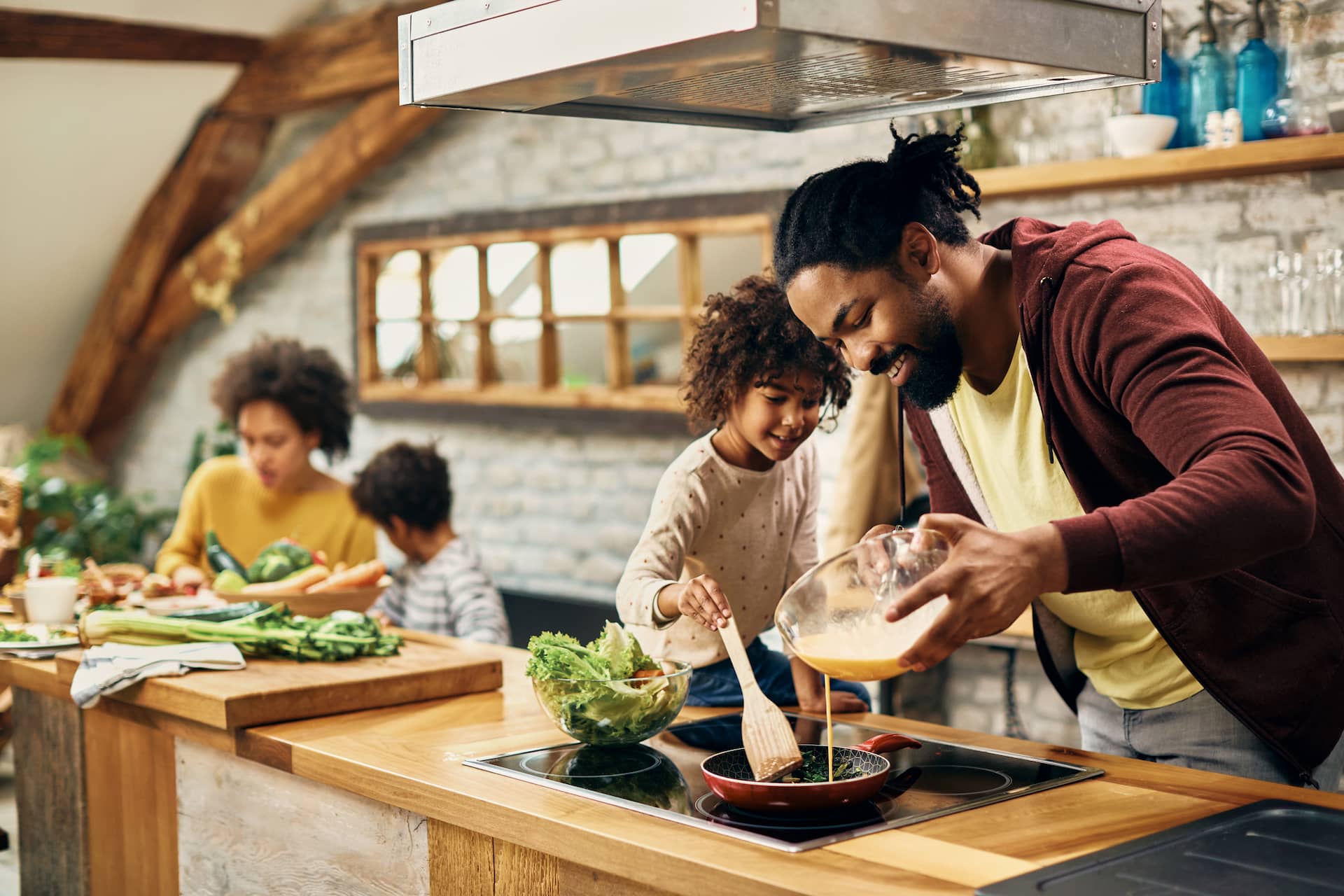 A man cooking breakfast with his young daughter
