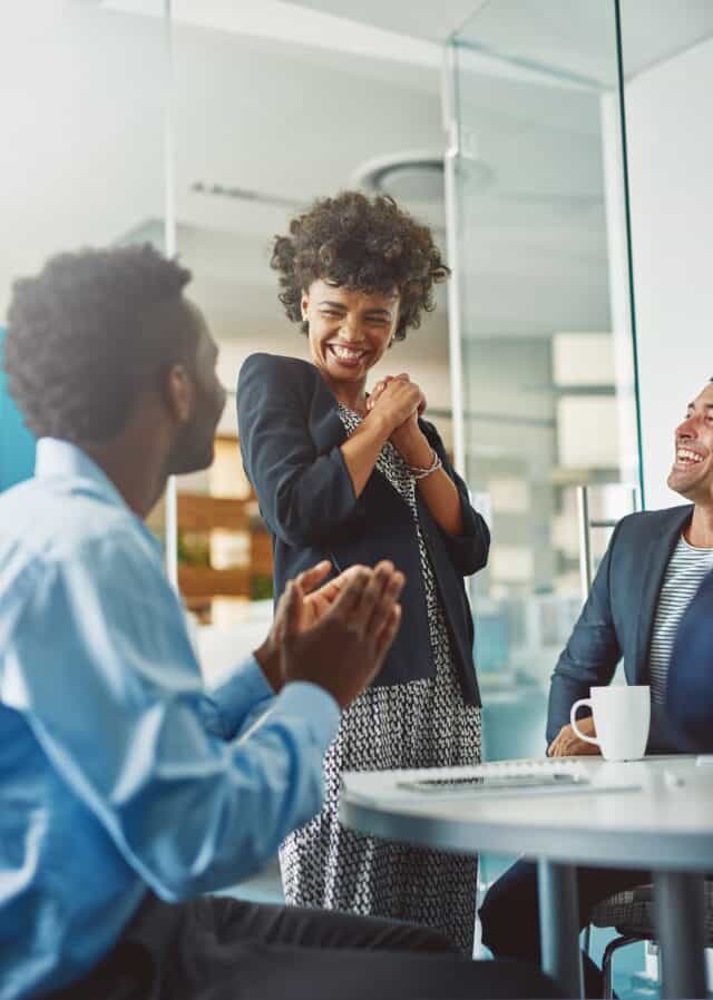 An employer talking and laughing with two of her employees