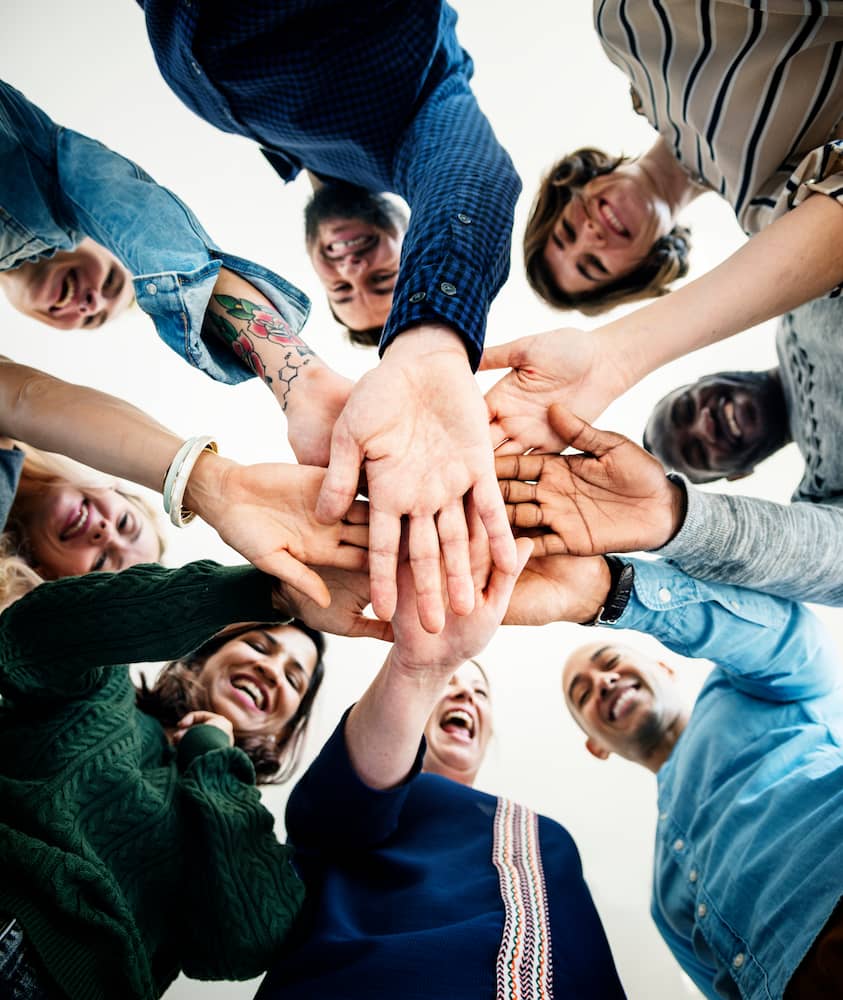 a group of people putting their hands together