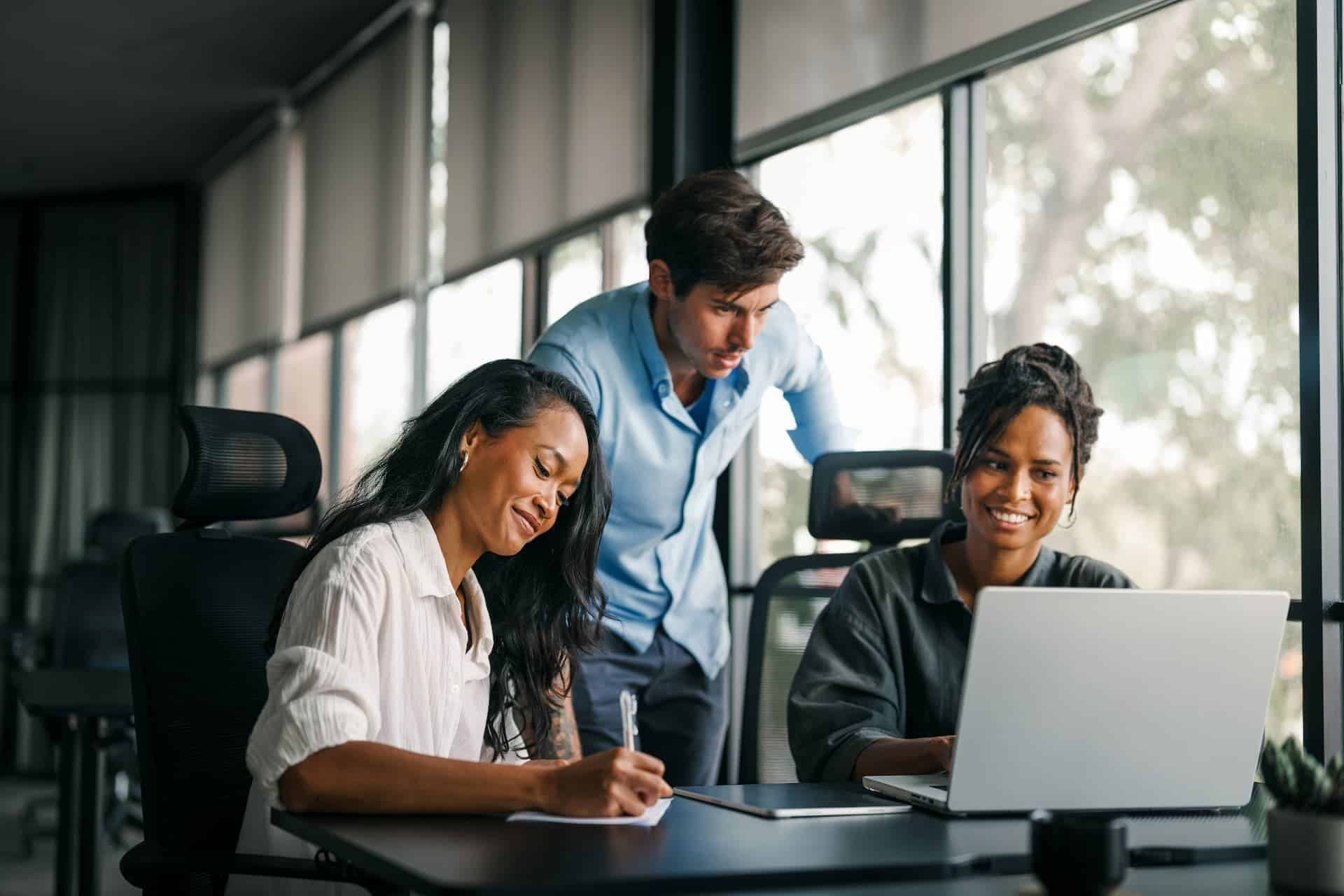 A diverse team of insurance agents collaborating around a desk.