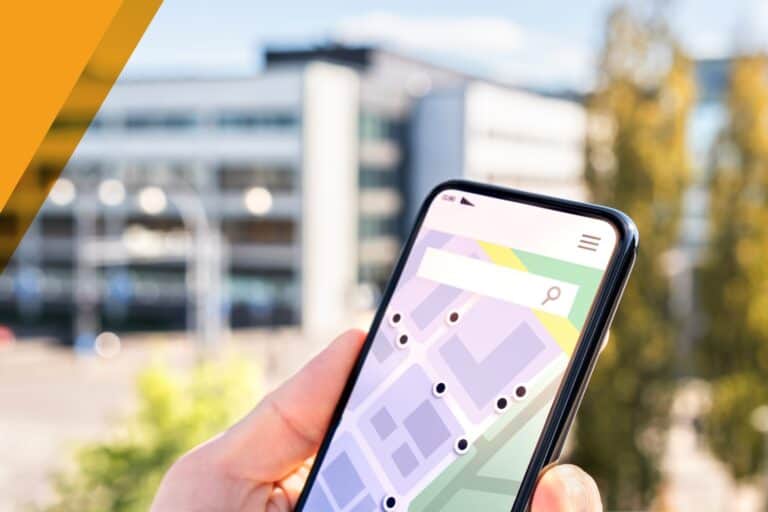 A person holding a smartphone displaying a local map search app outdoors in an urban setting