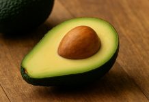 Jumătate de avocado proaspăt pe o masă rustică, simbol al sănătății și feminității