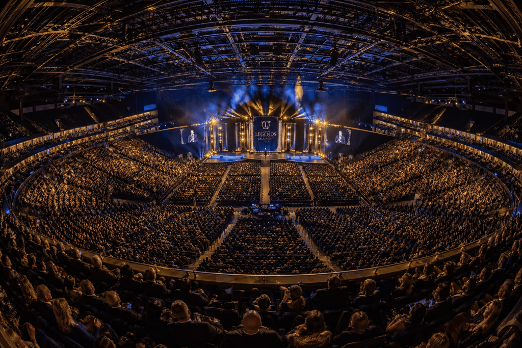 Illustrative panoramic view of a full indoor arena and illuminated stage
