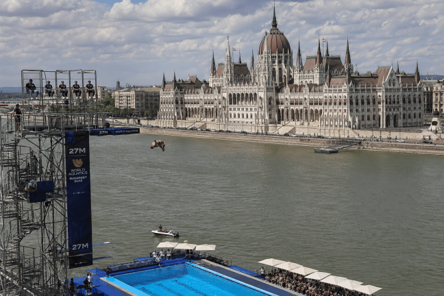 Toronyugró a 27 méteres platformról a World Aquatics Budapest 2022-n, háttérben a Parlament épülete