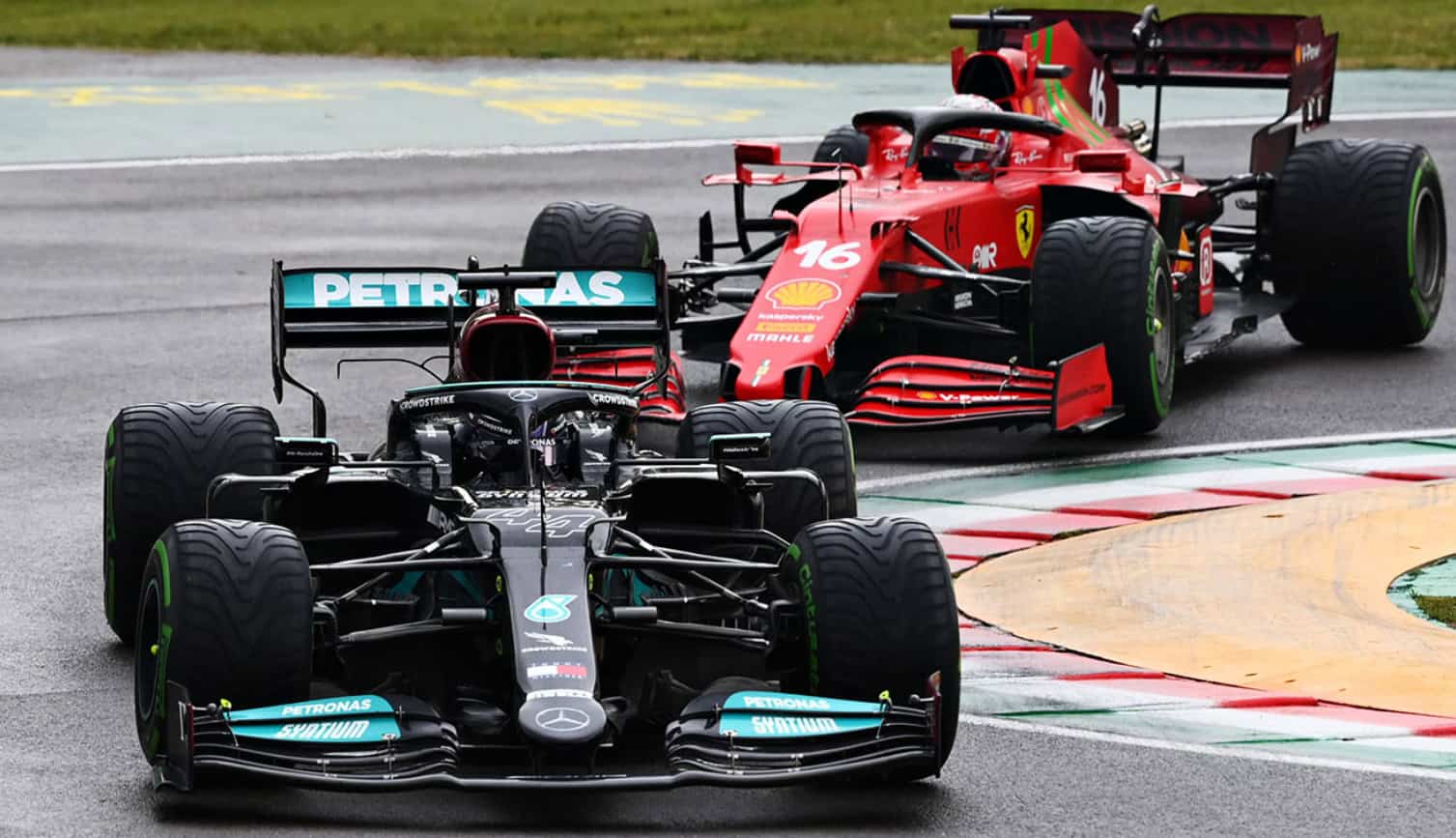 Two Formula 1 race cars compete on the track, one a black Mercedes and the other a red Ferrari, showcasing high-speed action during a race.