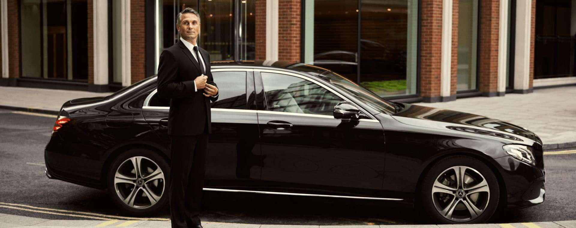Luxury black sedan with professional chauffeur — Budapest executive travel and VIP service