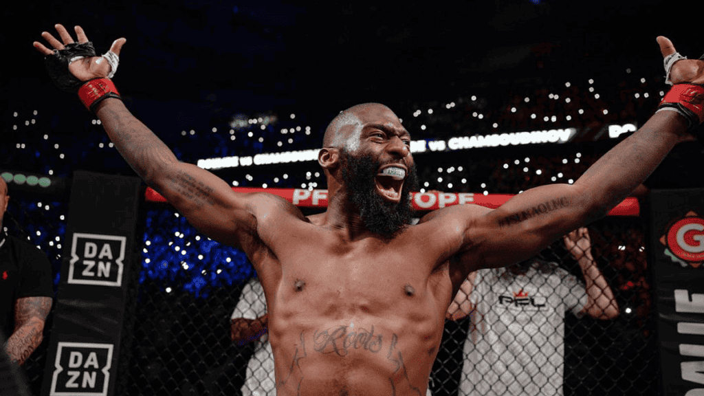 MMA fighter celebrating triumph in the octagon with arms raised.