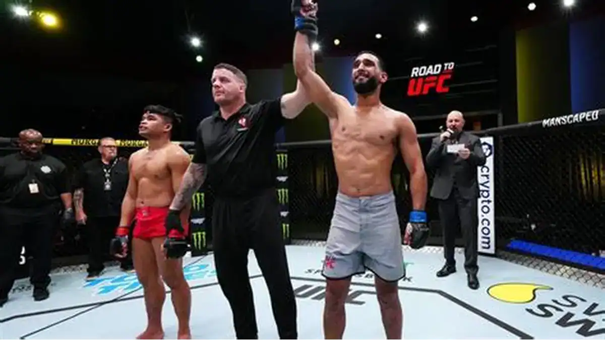 Two fighters in MMA cage celebrating victory after match.
