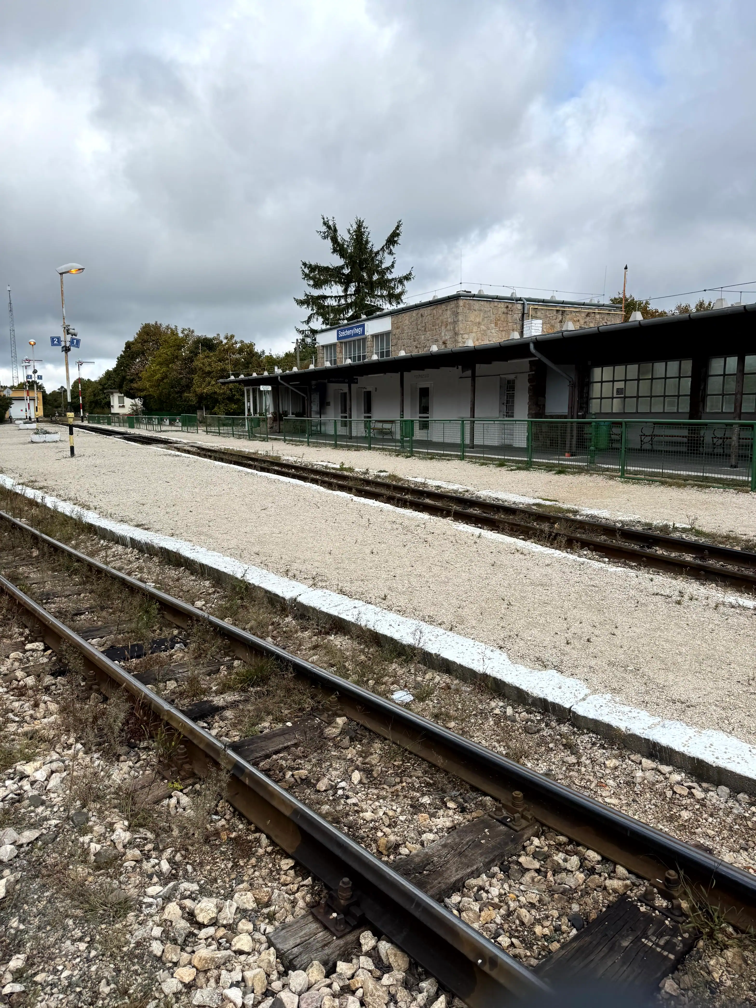 Train station platform in Budapest, Hungary with tracks and station building.