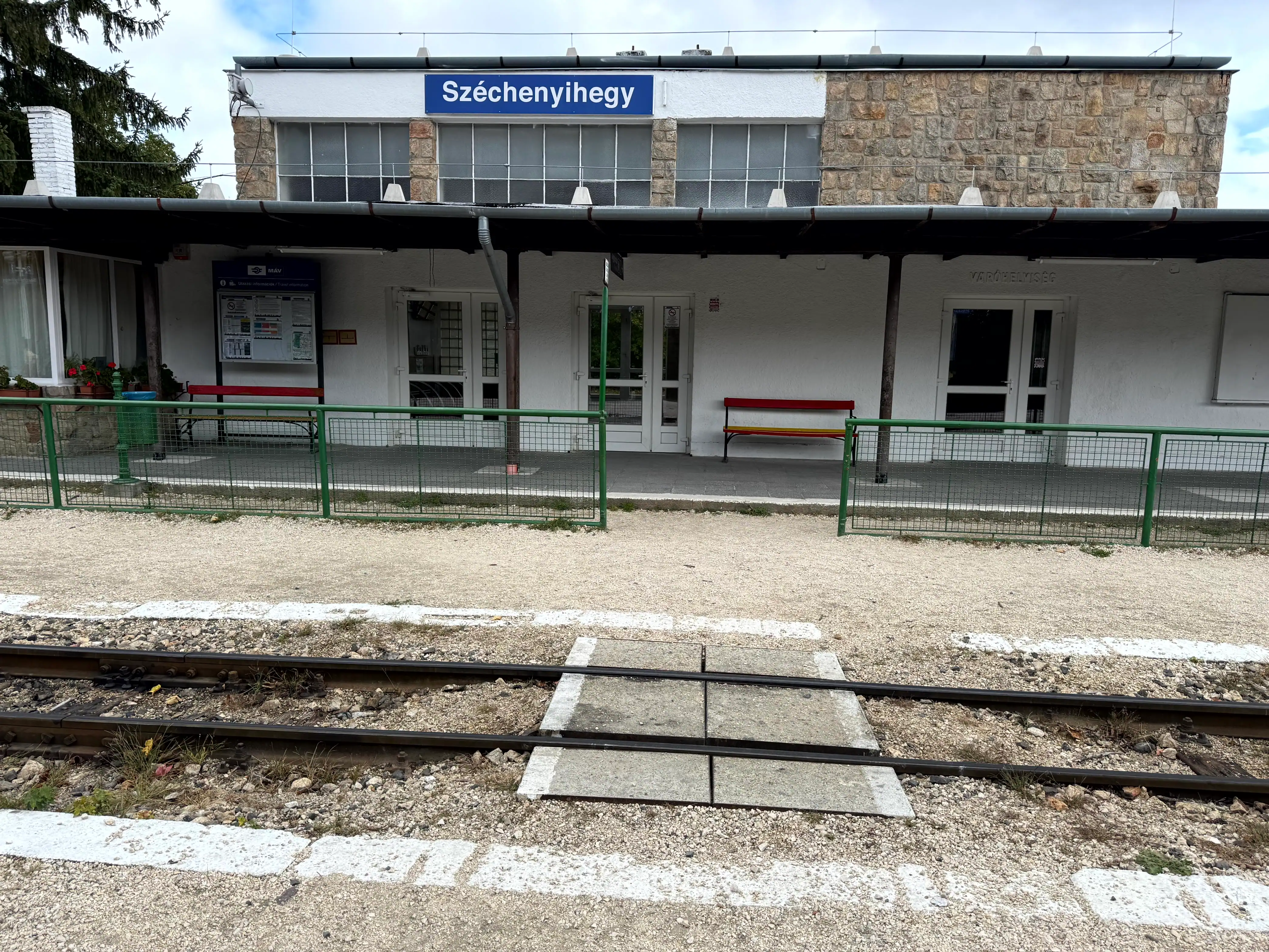 Train station platform with shelter and signage.