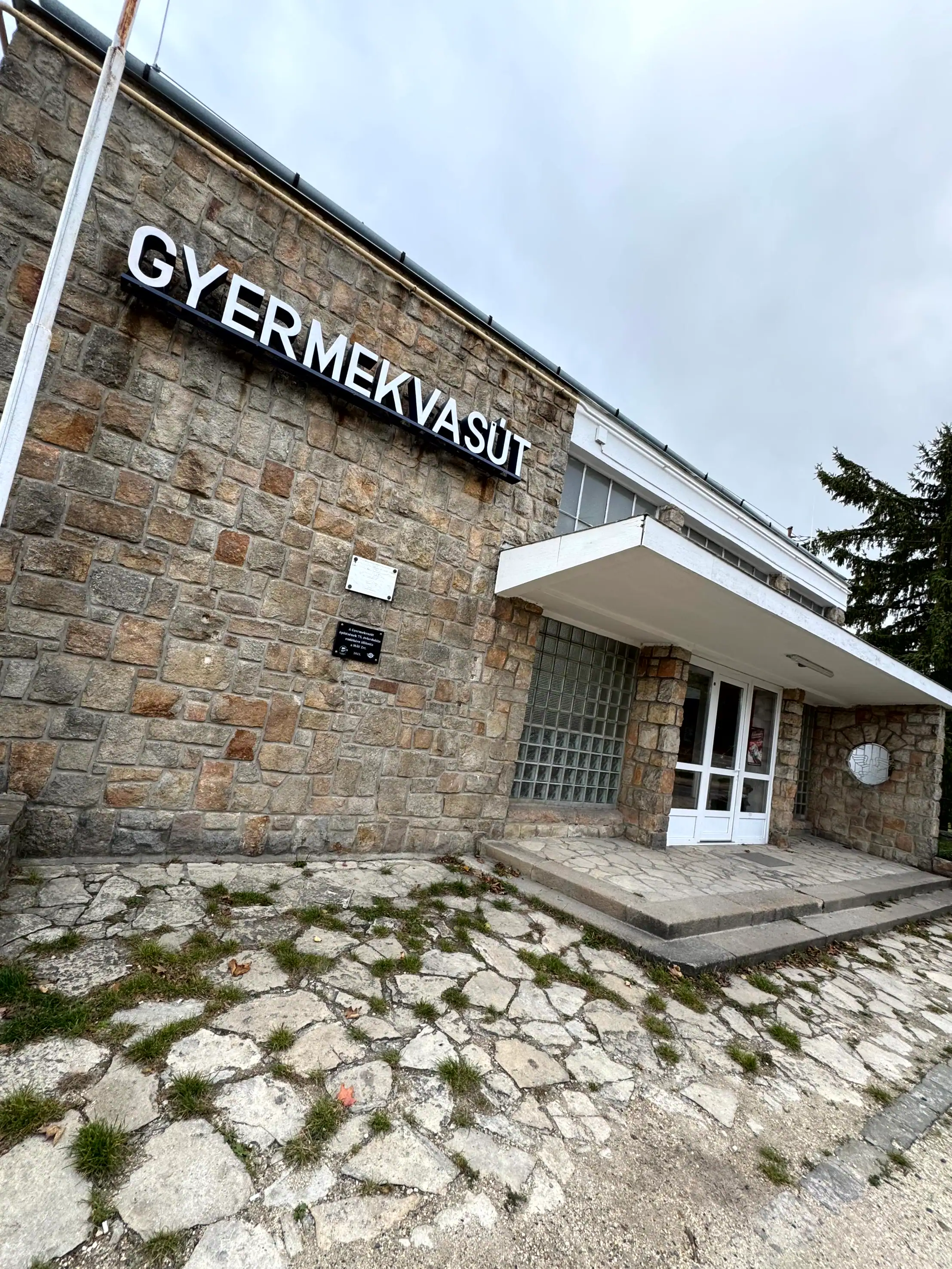 Gyermekvasút station entrance in Budapest with stone facade and signage.