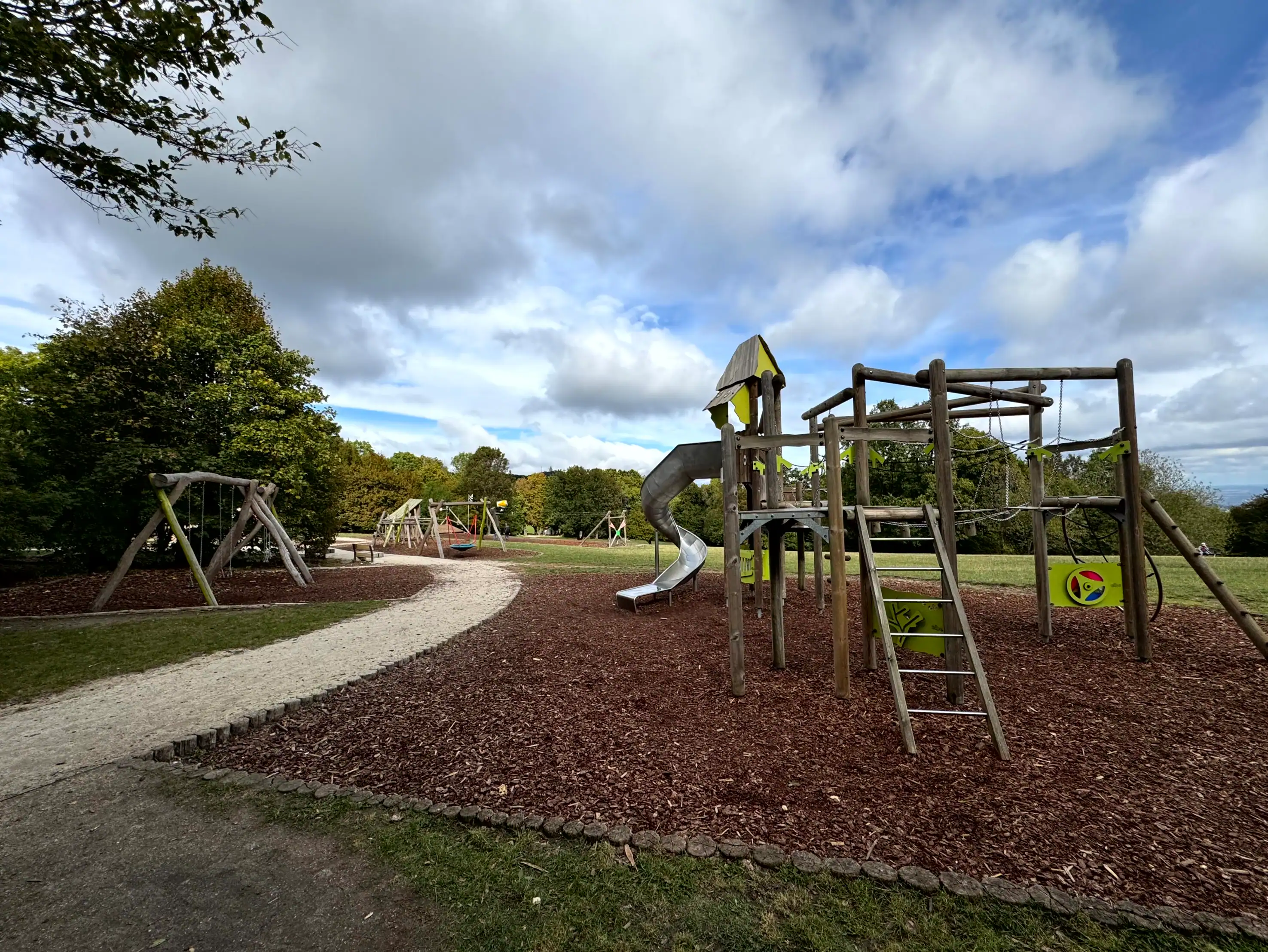 Playground with slides and swings in a park setting in Budapest.