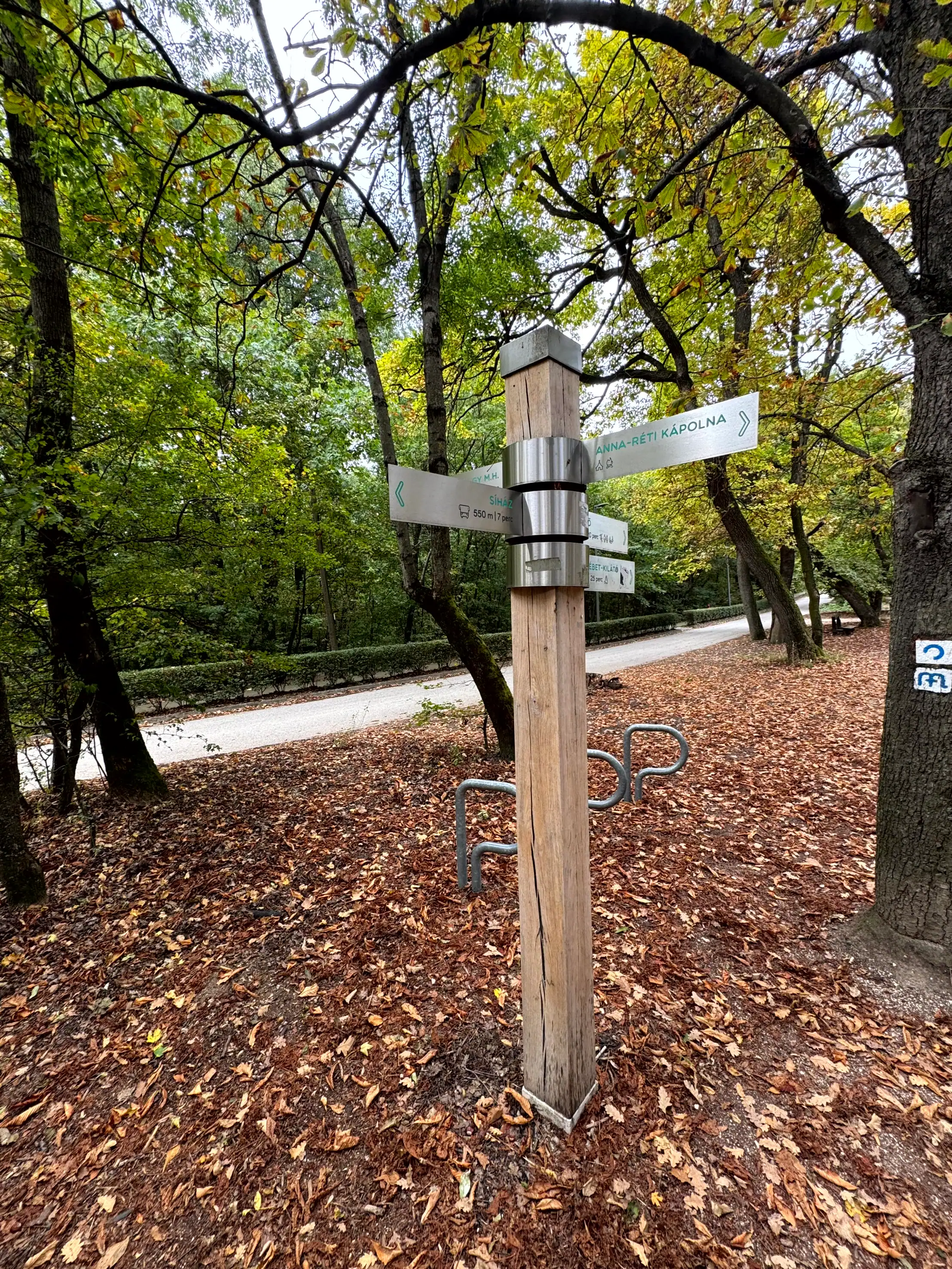 Hiking trail signpost in a lush green forest, guiding visitors through nature paths.
