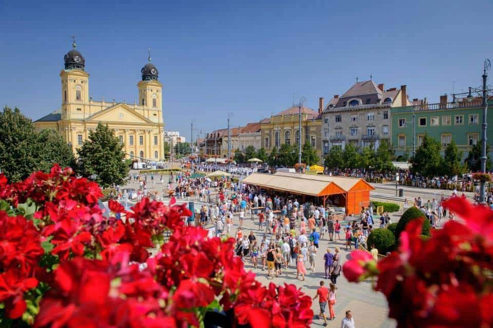 Budapest city square with historic buildings and vibrant flower displays.