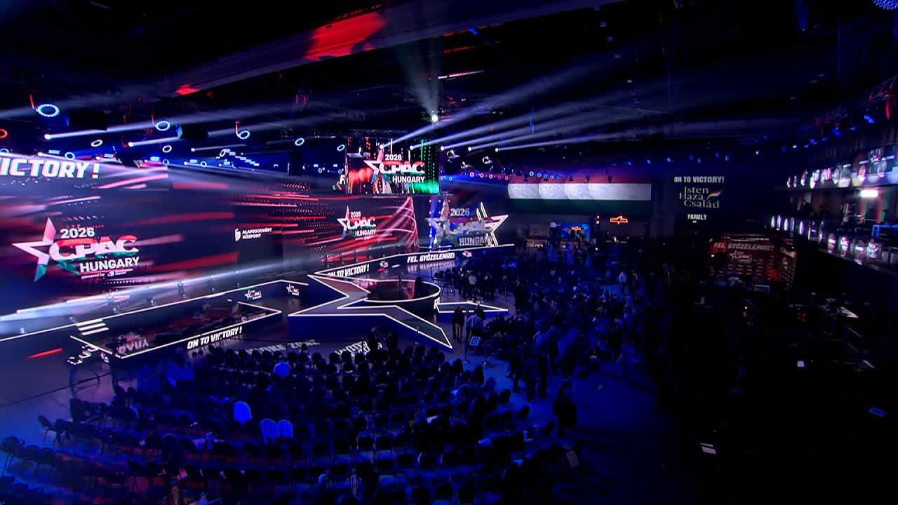 Victory banners and crowd at CPAC Hungary 2026 Budapest arena during speeches
