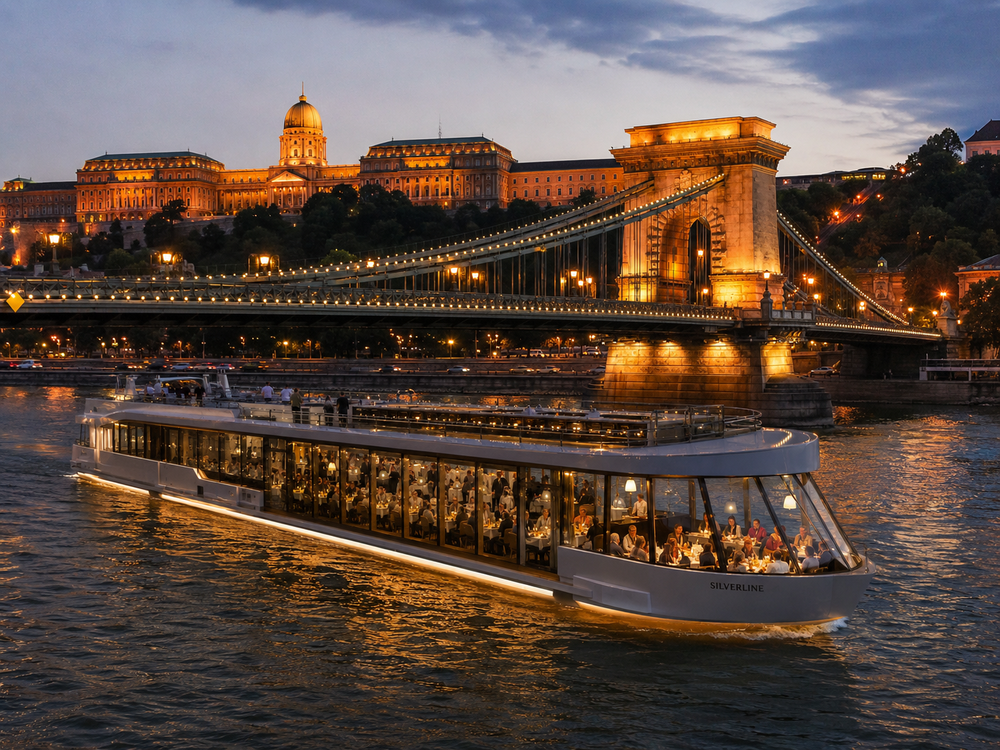 Illuminated Danube dinner cruise boat passing the Chain Bridge and Buda Castle at dusk in Budapest