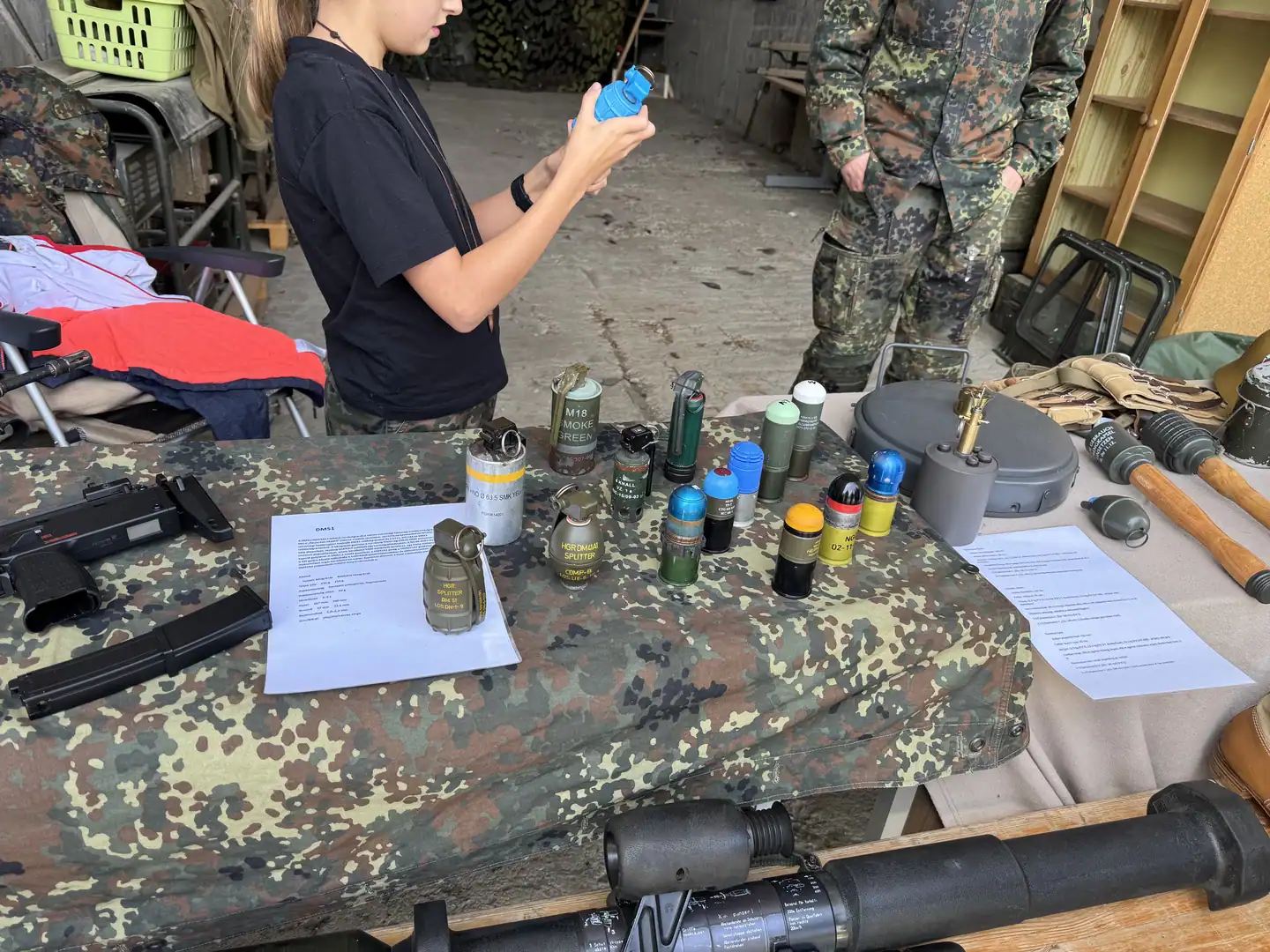 A young visitor examining inert training devices at an educational display