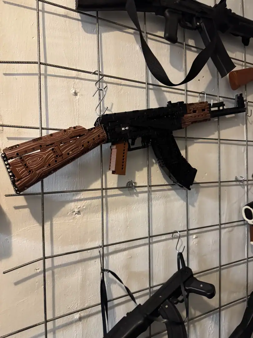 A building-block model of a rifle displayed on a wall rack