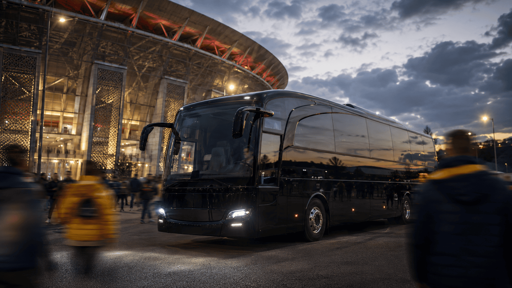 Team coach parked in front of a stadium as supporters arrive