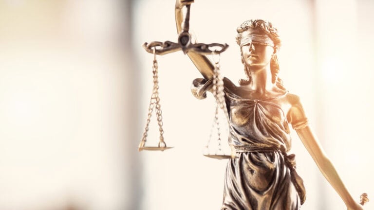 Statue of Lady Justice holding scales, symbolizing fairness in securities law.
