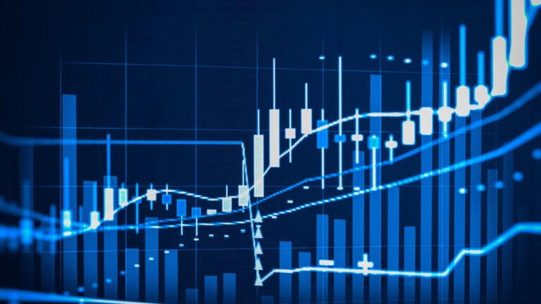 Stock market chart with rising and falling blue candlesticks and lines.