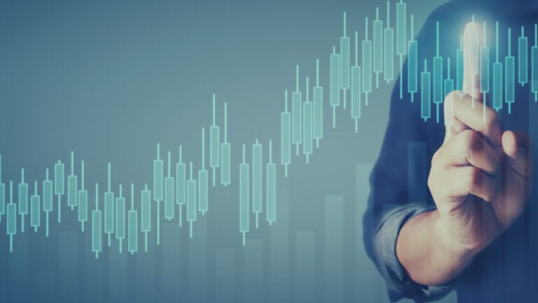Businessperson touching a rising stock chart with a finger.