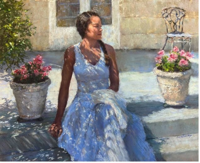 Woman in blue dress sitting outdoors during pastel painting workshop.