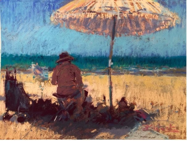 Relaxed beach scene with a person sitting under a large umbrella, enjoying a sunny day.