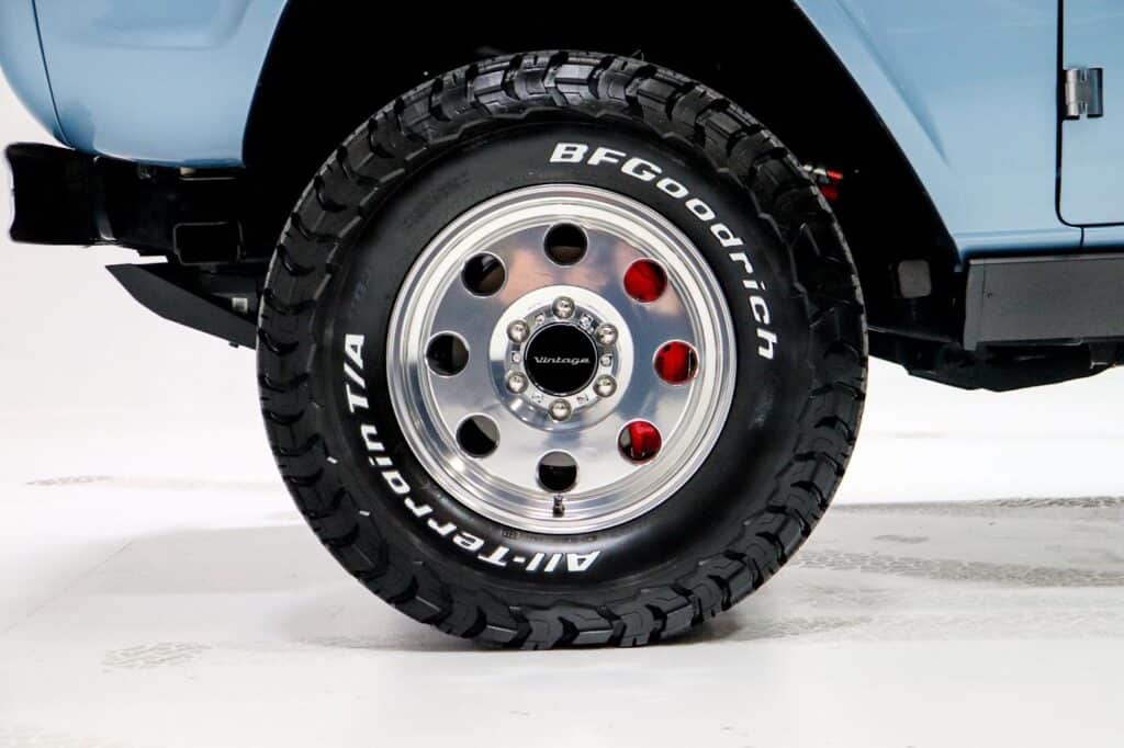 Vintage Modern car wheel featuring a rugged BFGoodrich All-Terrain T/A tire and polished aluminum rim, perfect for vintage-inspired off-road and adventure vehicles.