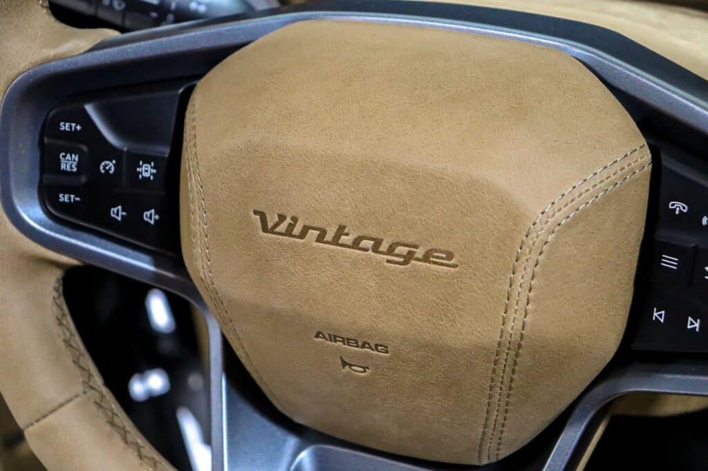 Luxurious beige leather airbag cover with "VW Tiguan" embossed, stylish steering wheel design with control buttons, blending modern technology with vintage-inspired automotive style.