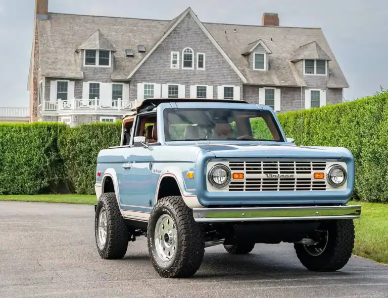Vintage modern off-road vehicle in front of a classic coastal house, showcasing retro style pickup trucks, Classic, vintage, retro, off-road, coastal house, modern design, nostalgic, outdoors, vehicle.