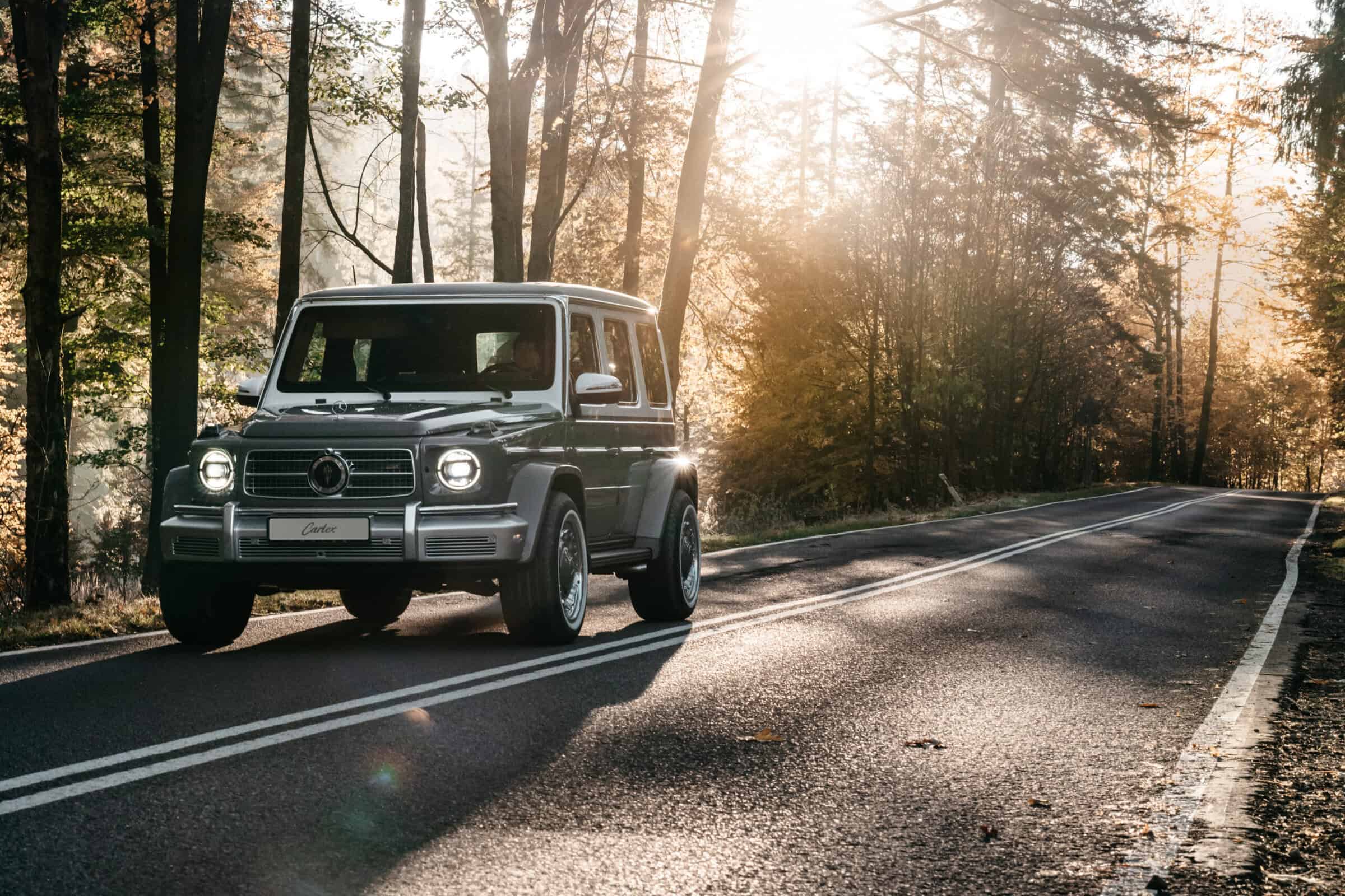 A classic vintage SUV driving on a scenic forest road during sunset, highlighting timeless design, outdoor adventure, and nature exploration. Perfect for vintage car and outdoor lifestyle enthusiasts.
