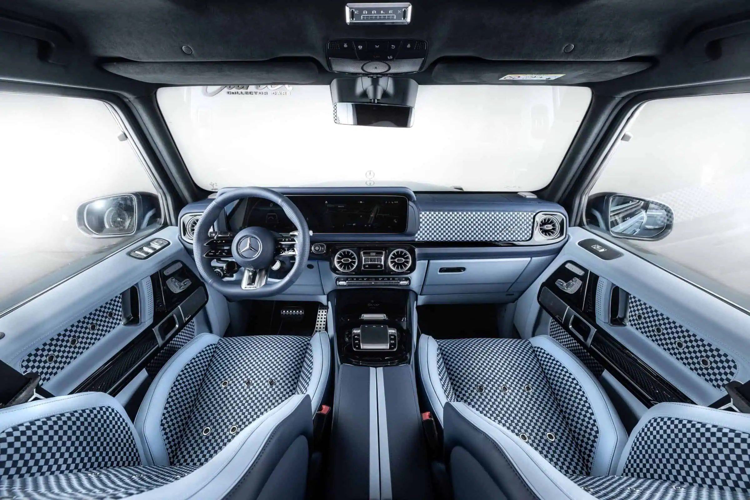 Luxurious vehicle interior featuring contemporary design, checkered upholstery, advanced dashboard, and premium comfort elements.