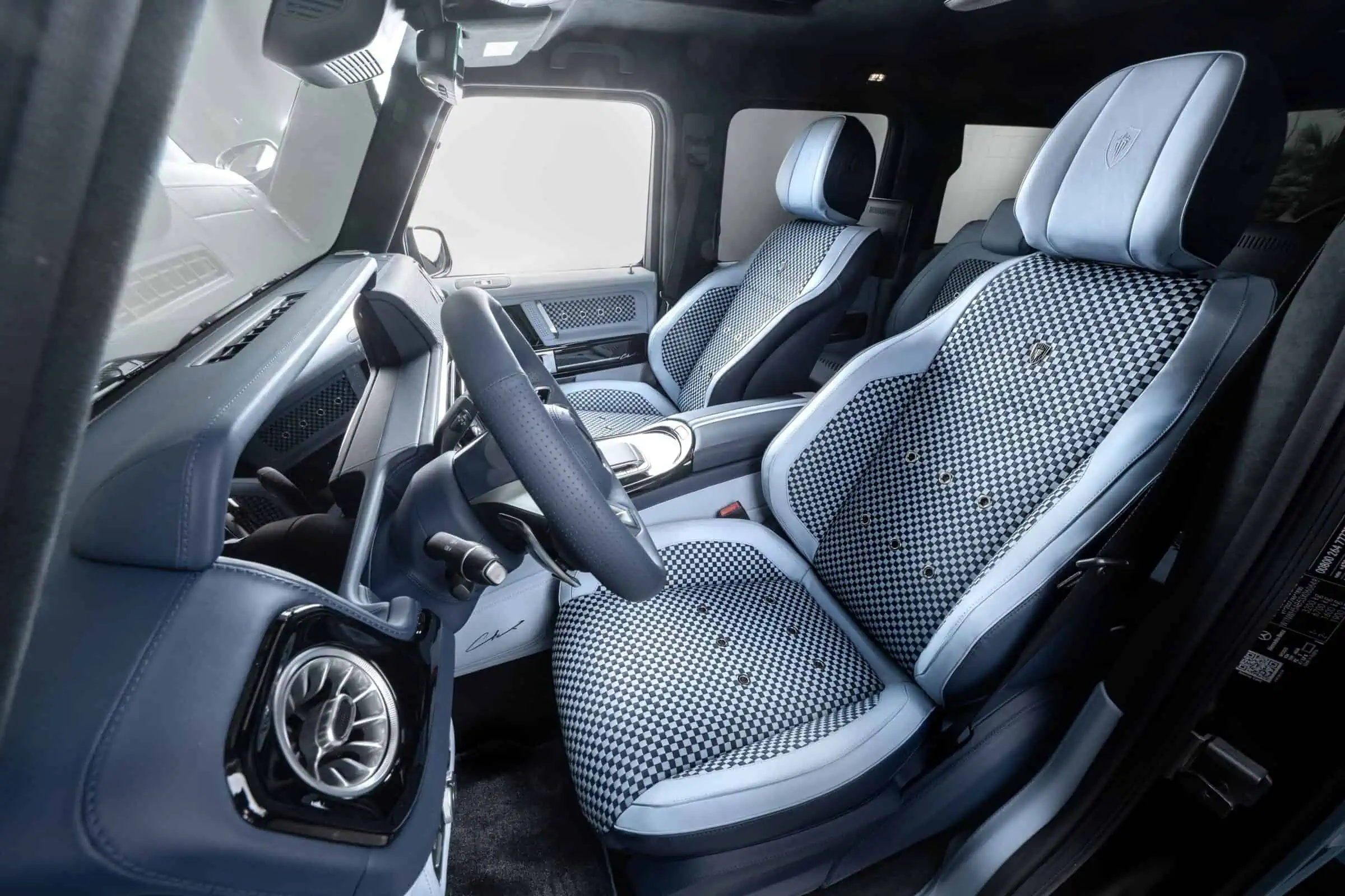Vivid close-up of a luxury vehicle's interior, showcasing stylish checkered seat covers, advanced dashboard, and modern amenities for a premium driving experience.
