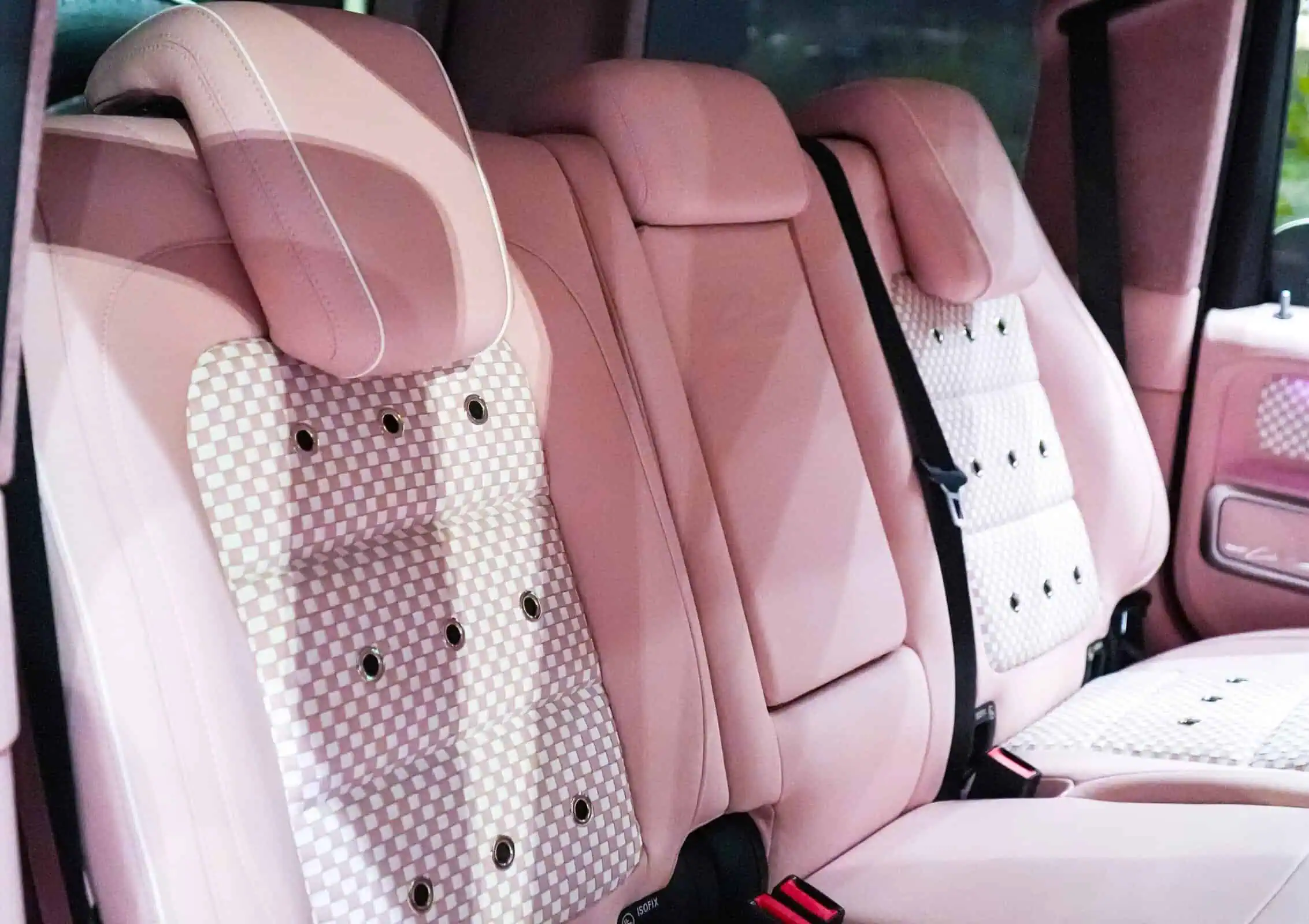Pink leather car seats with retro checkered pattern and headrest for vintage modern style and comfort.