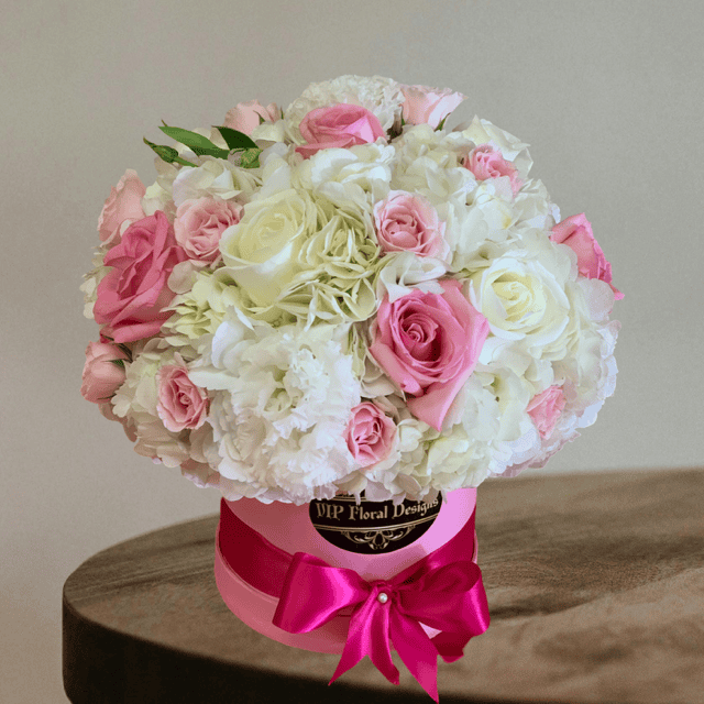 Elegant hat-shaped flower box with pink and white roses, perfect for special occasions and floral gifts.