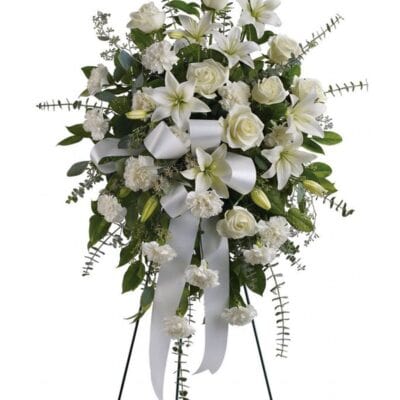 White roses, Asiatic lilies, chrysanthemums, and mini carnations are delicately arranged with emerald palm fronds and other lush greens. 