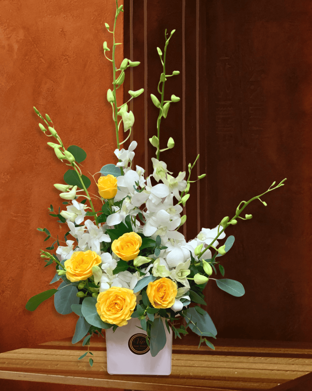 Rays of Elegance" flower arrangement in Las Vegas, Nevada - A stunning bouquet of white dendrobium orchids and yellow spray roses beautifully presented in a white cube vase