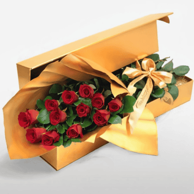 Lush red roses in a luxurious gold gift box with elegant wrapping, perfect for special occasions or romantic gestures.