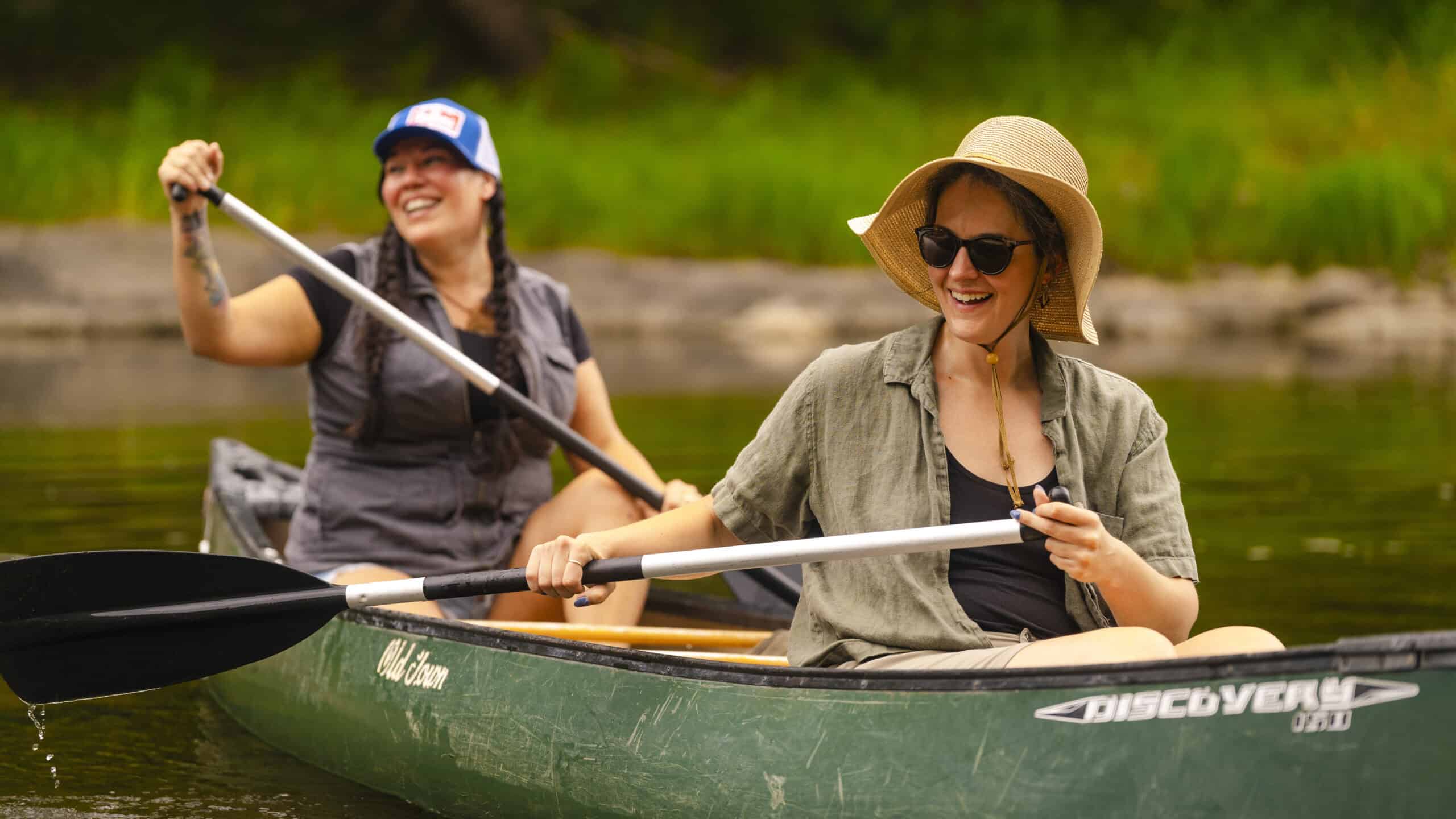 Women kayaking on a peaceful river in Hardy County, West Virginia in summer.