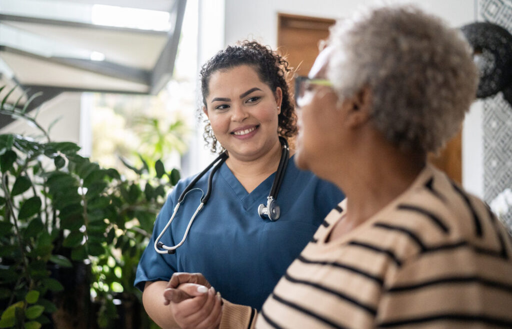 Compassionate senior care nurse assisting elderly resident at Vista Prairie at Garnette Gardens in Redwood Falls, MN.