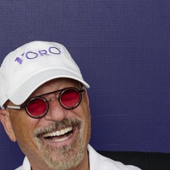 Voro branded white cap with logo and red sunglasses on smiling man.