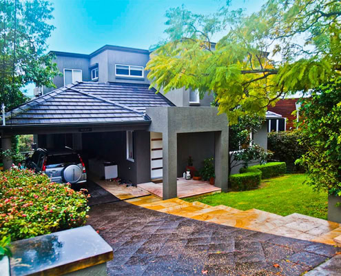 Contemporary residential house in Sydney with lush garden and paved driveway.