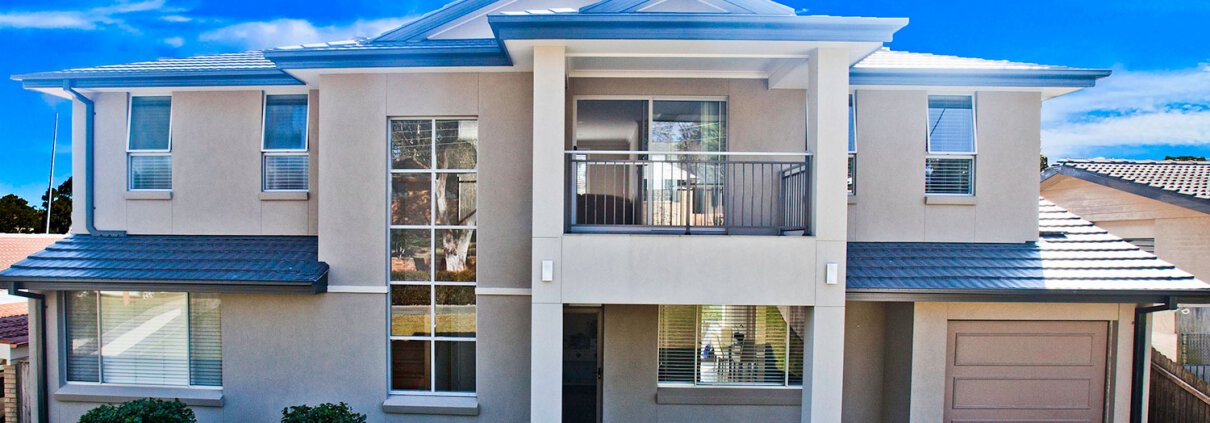 Modern Sydney home with balcony, large windows, and garage.