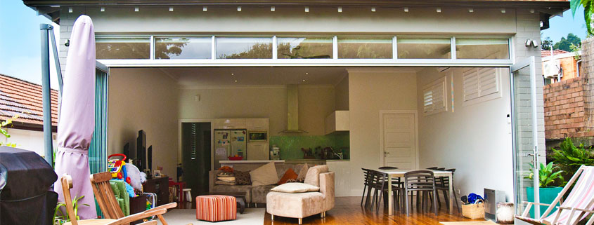 Interior view of a renovated Sydney home showing a spacious open-plan living area with outdoor acces.