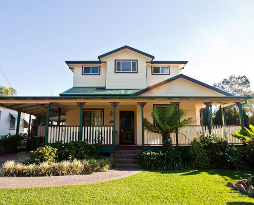 Beautiful Victorian-style house with a spacious front porch and lush garden in Sydney.